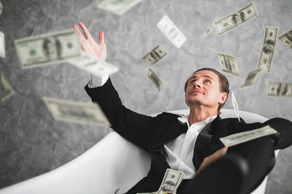 Rich man with money flying around him
