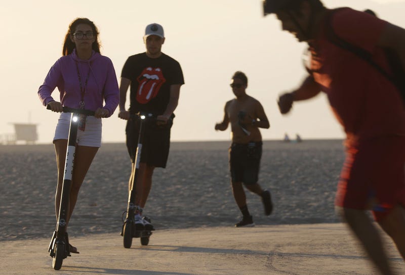 FILE - People ride Bird electric scooters along Venice Beach on Aug. 13, 2018 in Los Angeles. Shared e-scooter startups Bird and Lime had rapidly expanded in the city at the time, prompting complaints from some city residents who believed them to be dangerous for pedestrians and said they sometimes clog sidewalks.