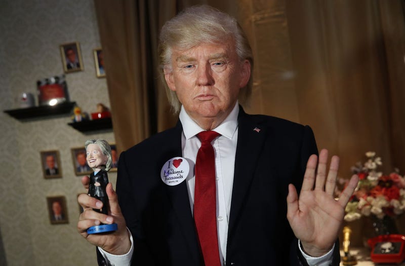 An actor wearing a silicon mask in the likeness of U.S. President Donald Trump poses poses with a Hillary Clinton doll during a presentation at Madame Tussauds on August 14, 2018 in Berlin, Germany. 
