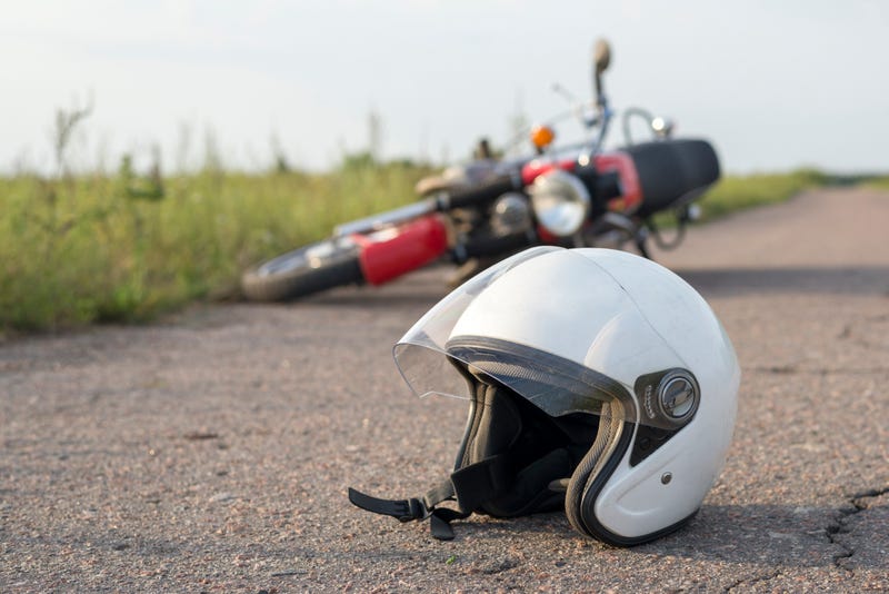 Motorcycle, helmet lying in road