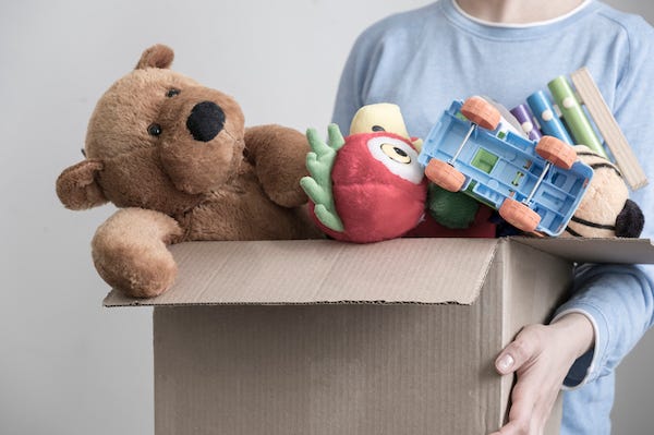 Man holding box of old toys