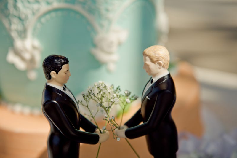 A cake topper with two men. 