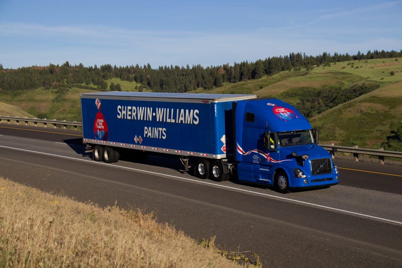 A Blue "Sherwin-Williams" Volvo Semi-Truck travels along a rural US Interstate.