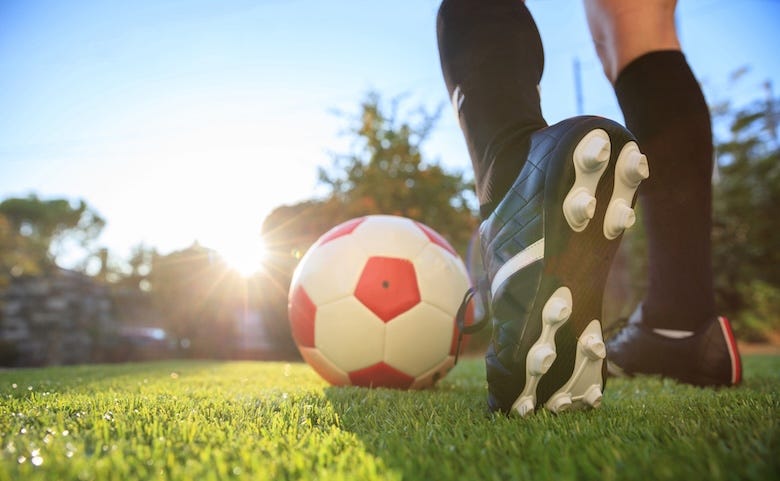 Female soccer player preparing to kick the ball on the field