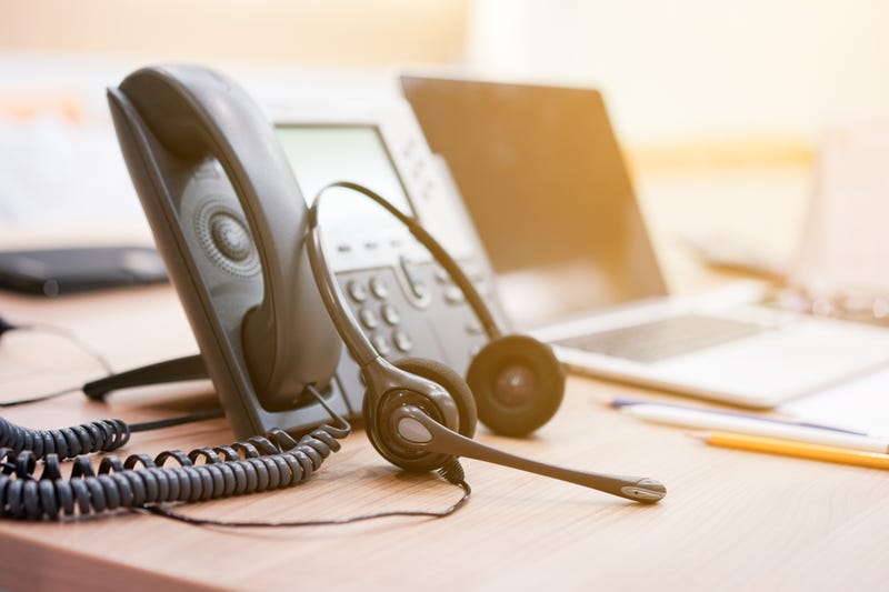 Closeup of someone's headset and phone at a customer service call center.