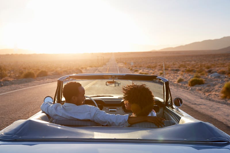couple in convertible driving through desert