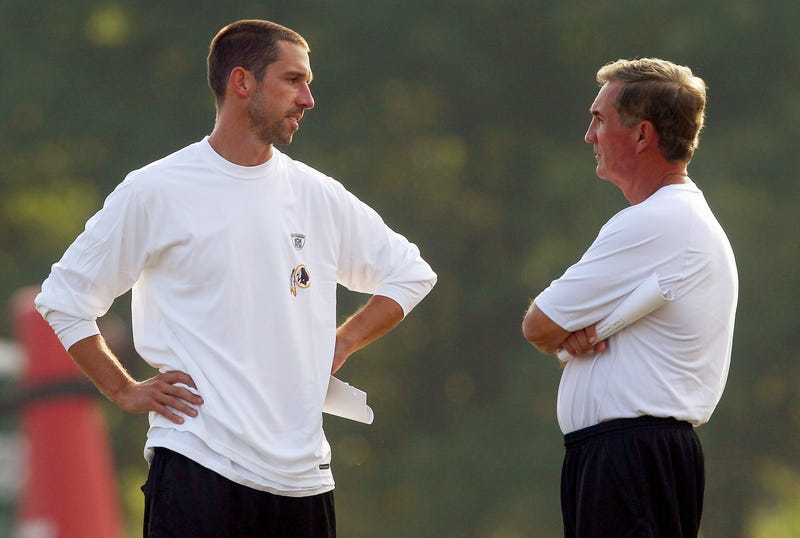 Head Coach Mike Shanahan (R) of the Washington Redskins talks with his son Kyle Shanahan (L) offensive coordinator for the team during Redskins training camp on August 6, 2010 in Ashburn, Virginia