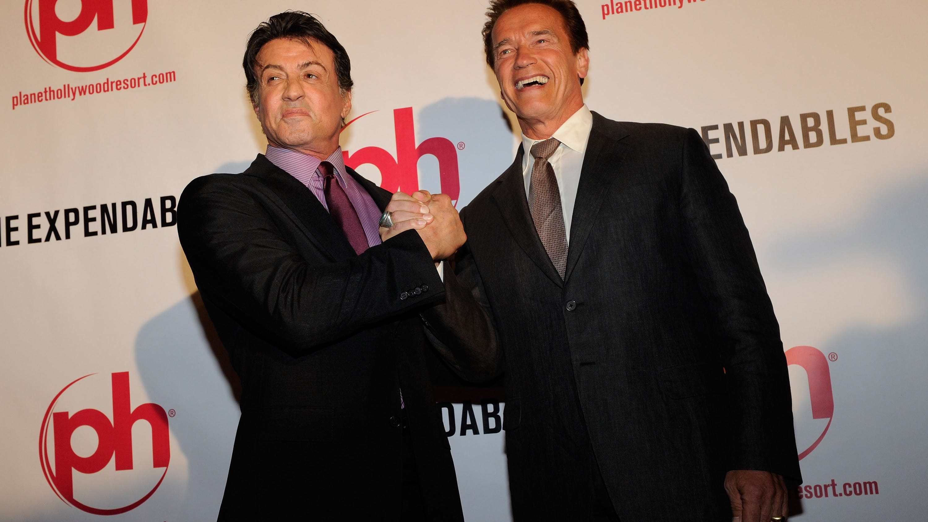 Arnold Schwarzenegger and Sylvester Stallone carve up jack-o’-lanterns with huge knives