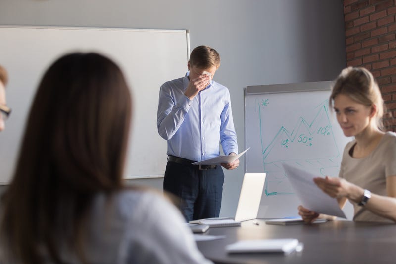 Stressed male speaker or presenter worried before making presentation for colleagues in meeting room, nervous employee wipe face scared to speak in public, afraid to present business report in office.