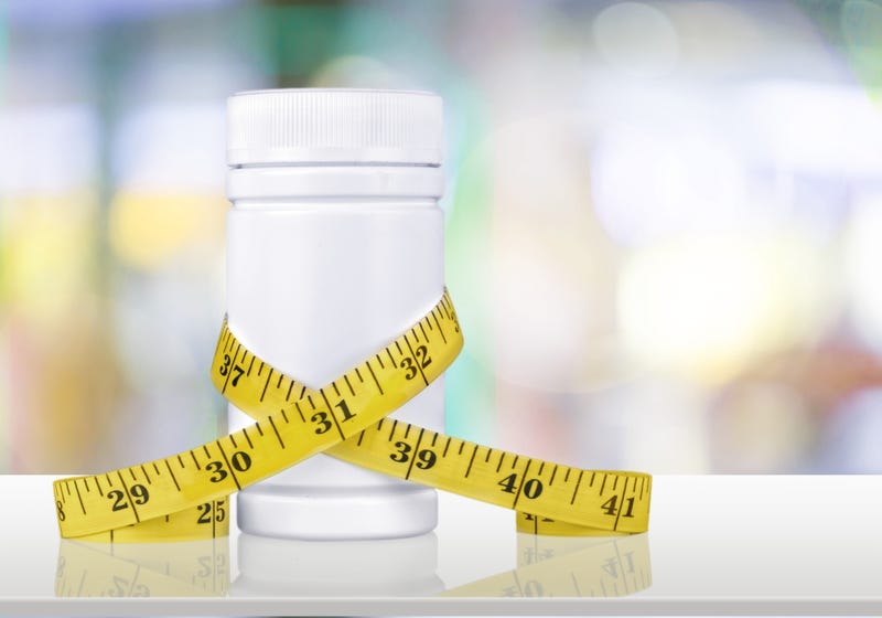 pill bottle with tape measure around its middle