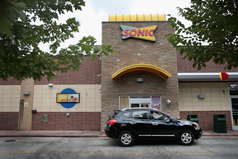 A customer picks up food at the drive-up window at a Sonic restaurant on September 25, 2018.