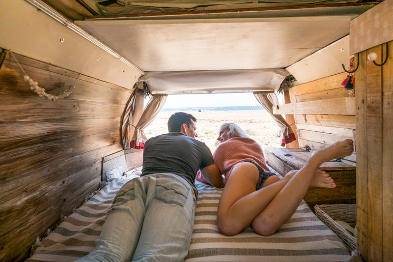 intimate and passionate alternative classic hand made van interior with caucasian couple of traveler parked in front of the ocean to enjoy freedom and different tiny house for the couple. enjoy lifestyle in summer