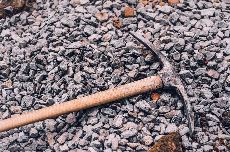 pickaxe lying in pile of rocks