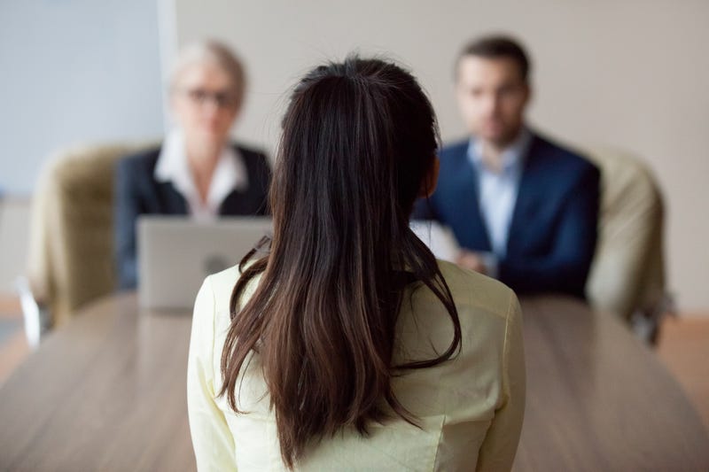 Back of woman's head as she speaks to her bosses.