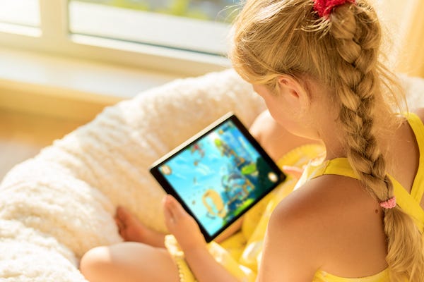 Young girl playing games on tablet