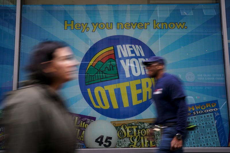 People walk past the New York Lottery Customer Service Center in Lower Manhattan.