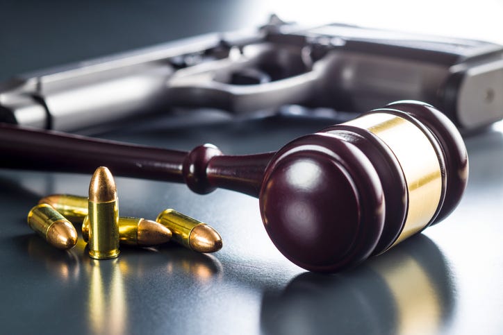 Gavel and gun on a table depicting gun legislation. 