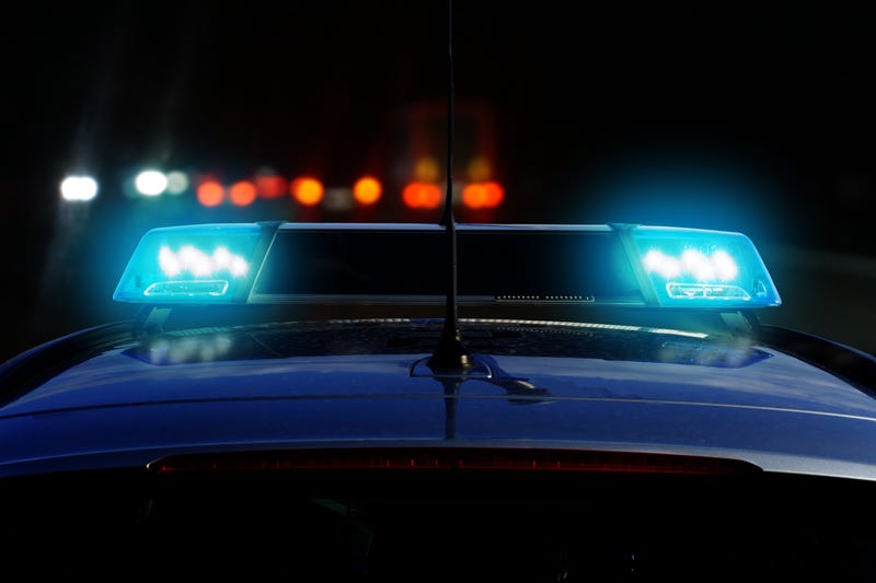 Patrol car on the road at night with flashing blue lights 