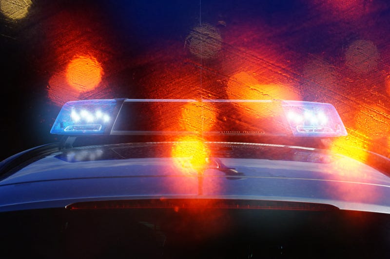 police patrol car on the road at night with flashing blue lights and backlights from other vehicles