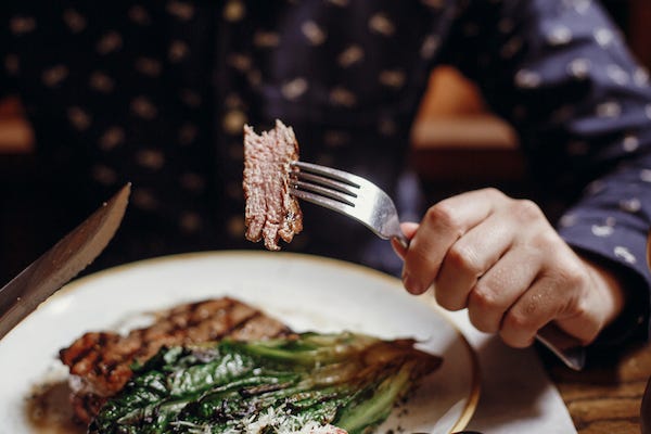 Man with a piece of steak on his fork