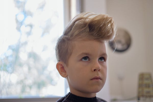 Little boy with hairstyle getting haircut