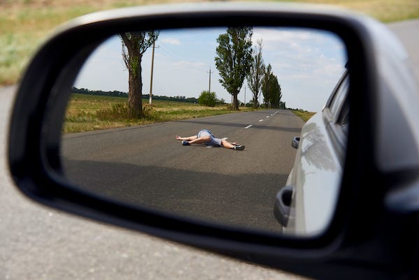 Man lying in the road after getting hit by car
