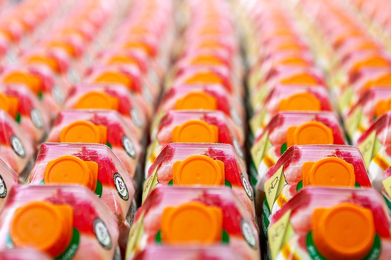 Fruit juices on store shelves in supermarket. Colorful carton boxes with plastic screw cap. Juice texture. Delicious refreshing drink. Top view.