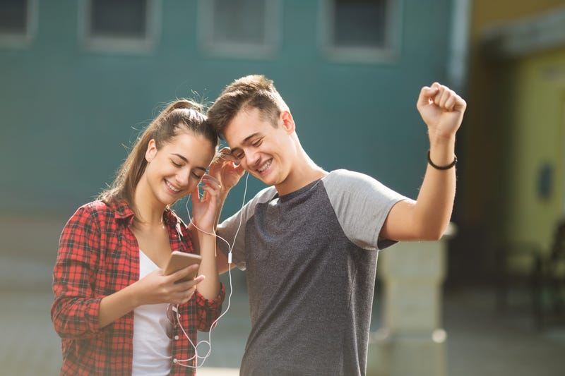 high schoolers listening to music on earphones