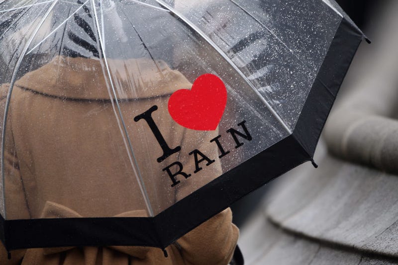 A woman carrying an umbrella that reads I love rain, walks across Parliament Square on November 8, 2010 in London, England.