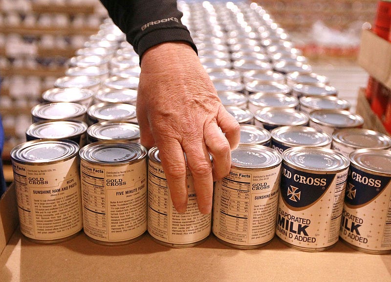 Kim Kinker packs cans of evaporated milk into boxes while volunteering with members of the San Francisco 49ers at the San Francisco Food Bank on November 9, 2010 in San Francisco, California. 