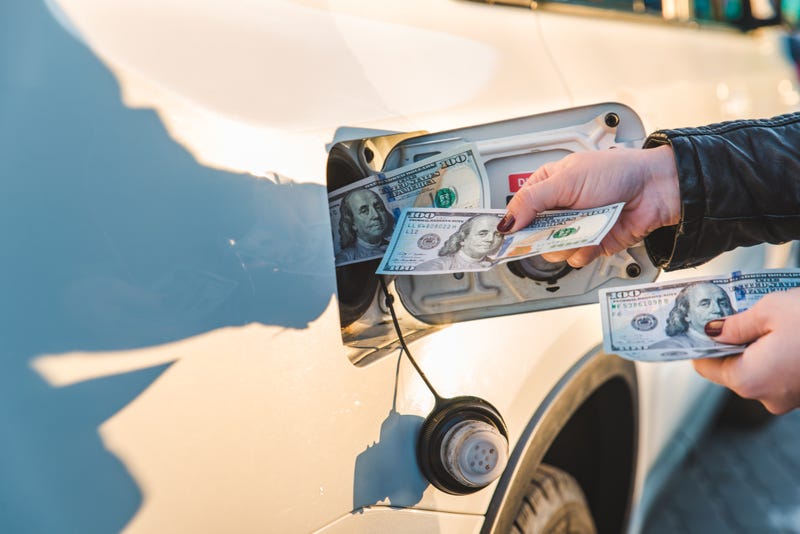 Woman put money to car tank. gasoline price hike
