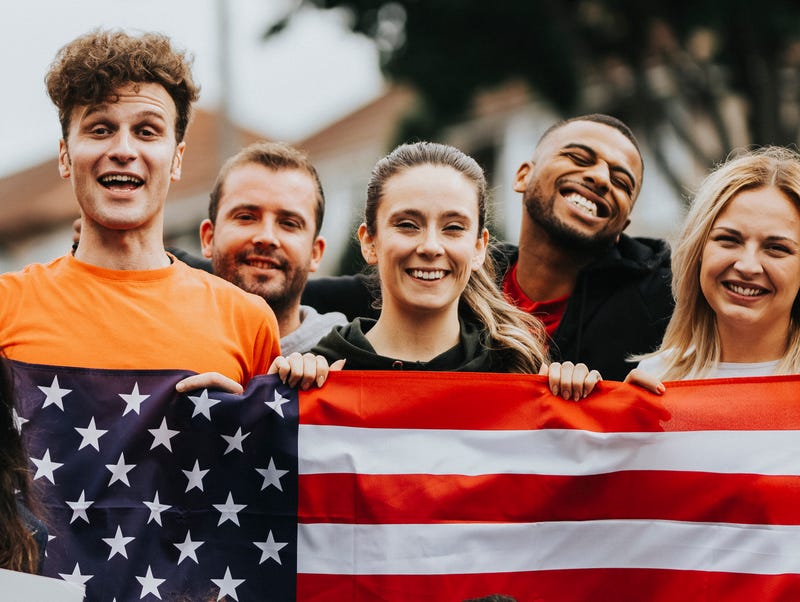 A group of young people hold up an American flag