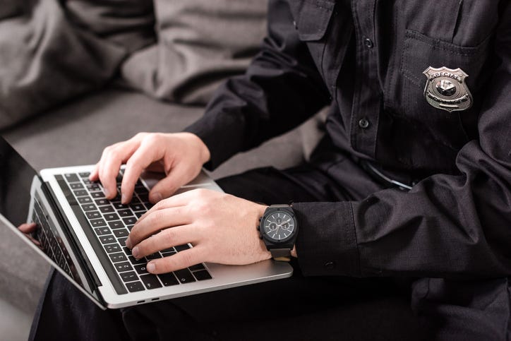stock image of a police officer using a computer