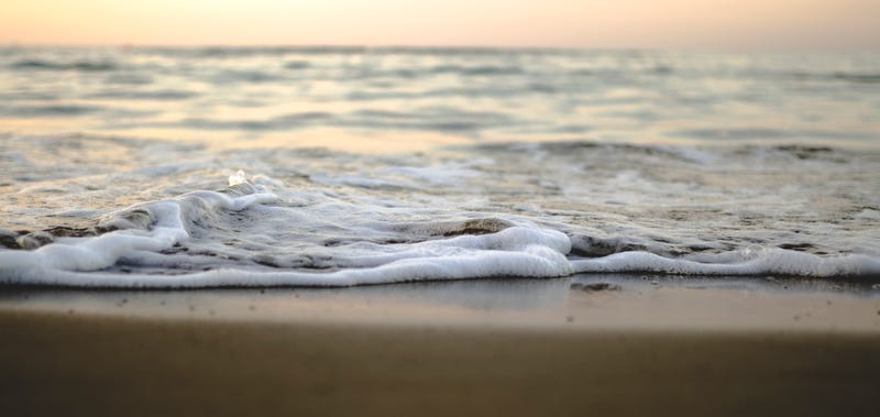 Water approaching shore on a beach.