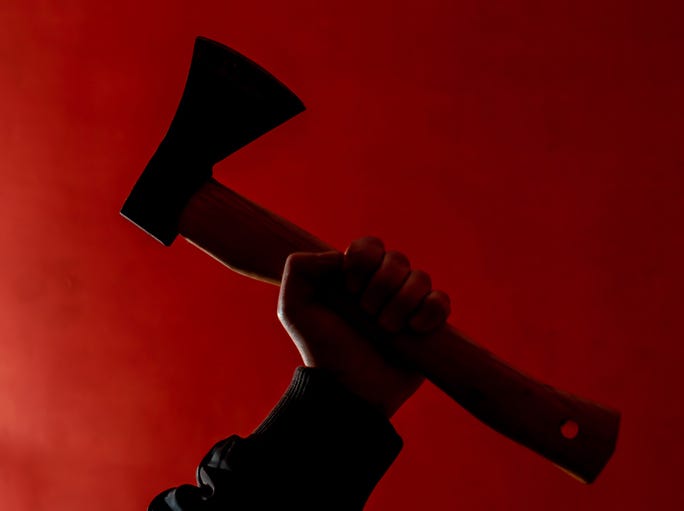 a man holding a hatchet on a red background