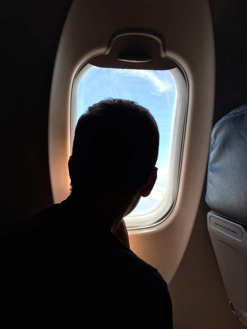 Teen looking out of airplane window. 