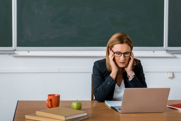 Female teacher with a headache in the classroom