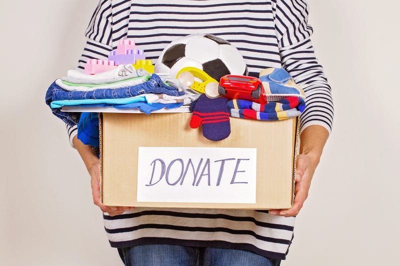 Woman holds box of toys to donate