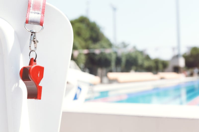 Lifeguard chair and whistle at an outdoor pool. 