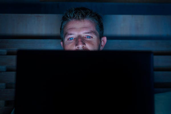 Man looking at computer late a night