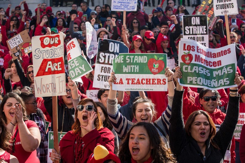 Educators, parents, students, and supporters of the Los Angeles teachers strike wave and cheer in Grand Park on January 22, 2019 in downtown Los Angeles, California.