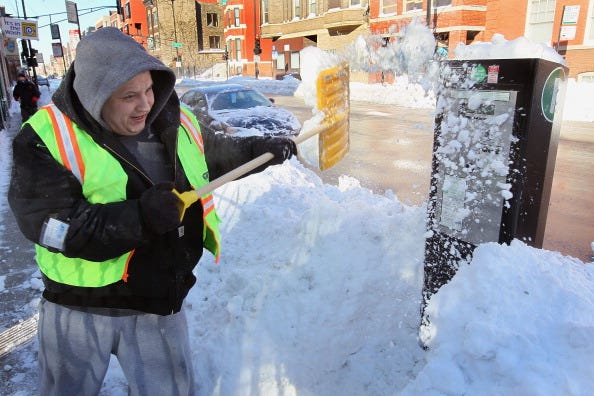Gustavo Prieto clears snow from a parking meter February 3, 2011 in Chicago, Illinois. Throughout the city residents continue to dig out from more than 20 inches of snow that fell on the area Tuesday and Wednesday. (Photo by Scott Olson/Getty Images)