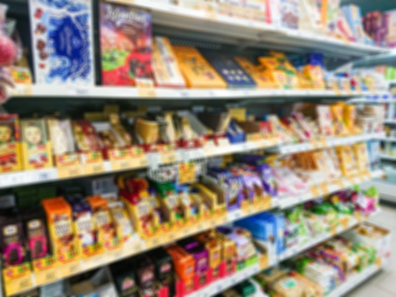 Blurred abstract image. Goods on the shelf of a grocery store. Chocolate and chocolates in boxes.