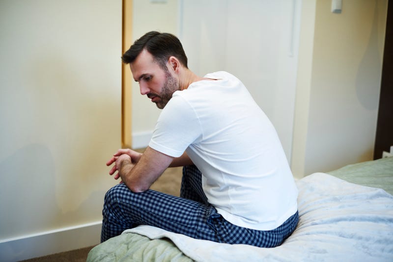 Worried man sitting on bed