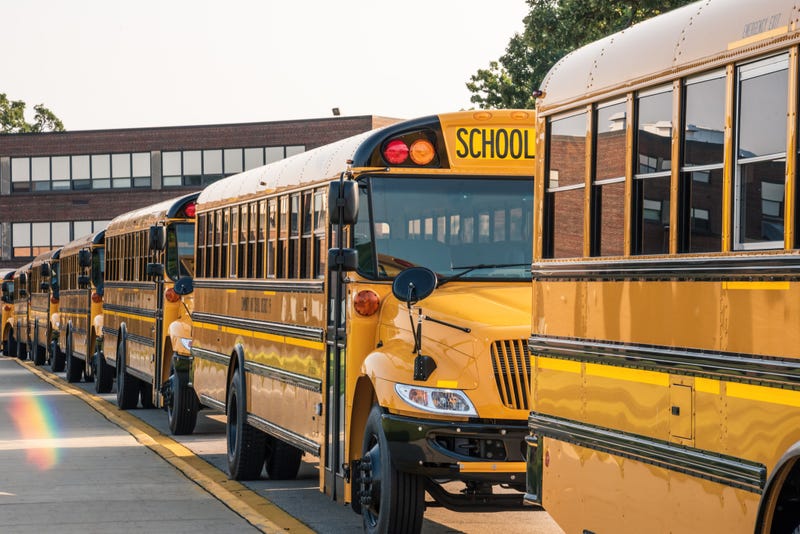 School buses lined up ready to pick up kids - stock photo