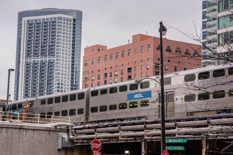 The Metra train passes above on elevated tracks, downtown Chicago. Millions take public transit yearly in the city. 