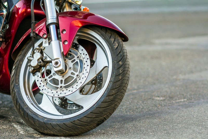 Front wheel of sports motorcycle on road.