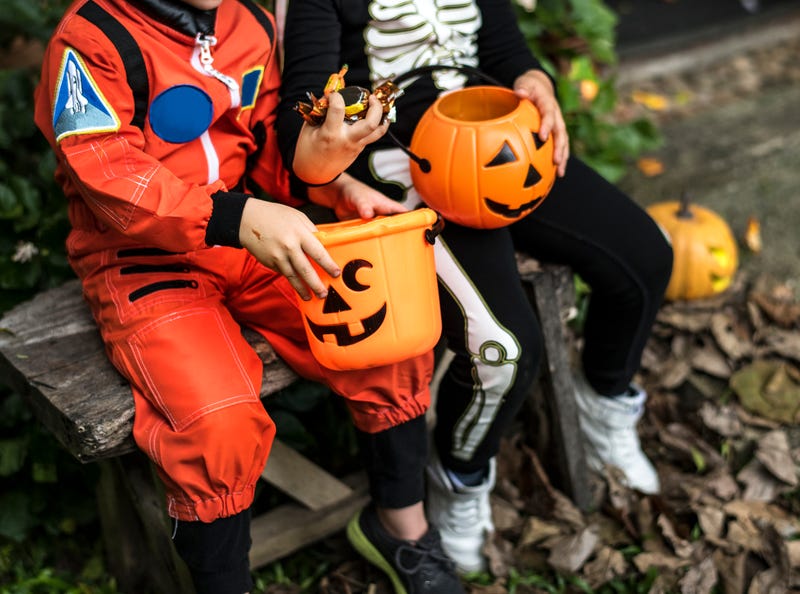 two trick-or-treaters go through their haul