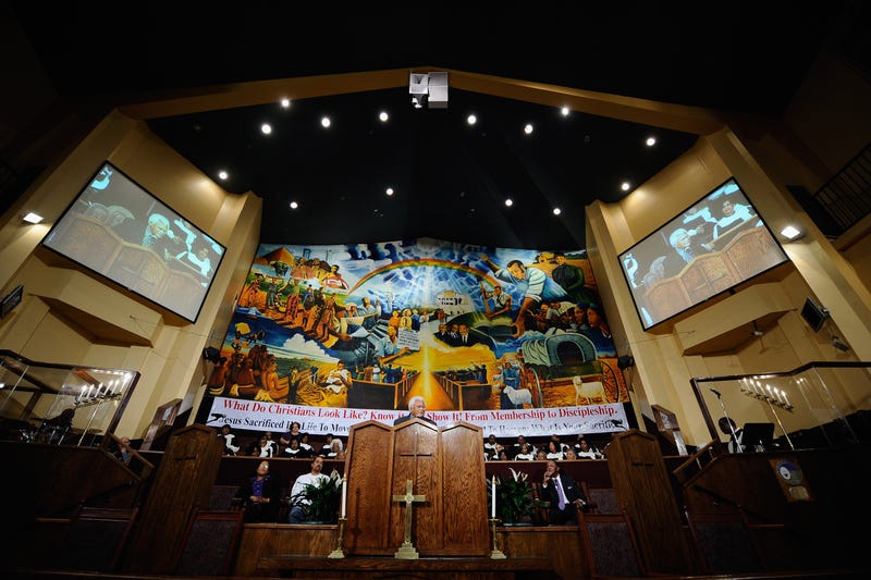 inside of a church with a mural behind the pulpit