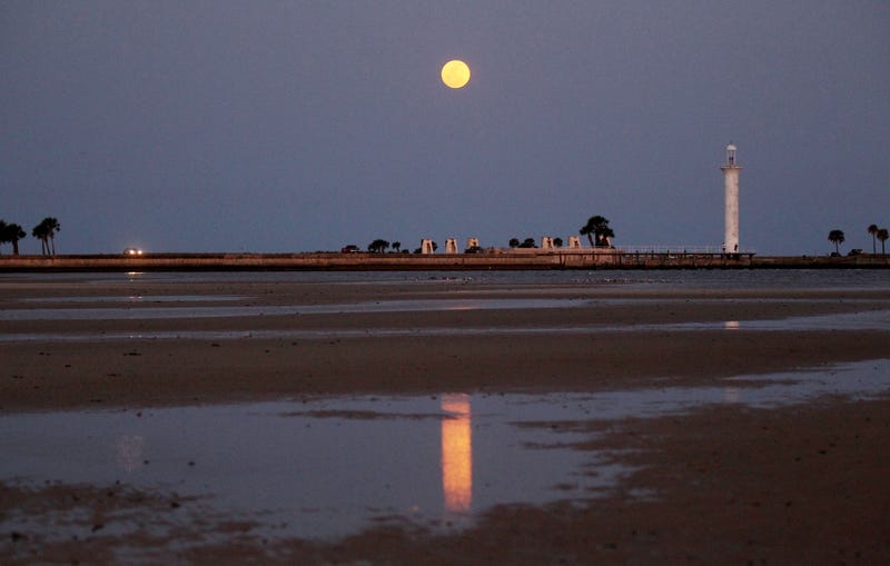 A full moon lights up the night sky at the beach in Biloxi, Mississippi.
